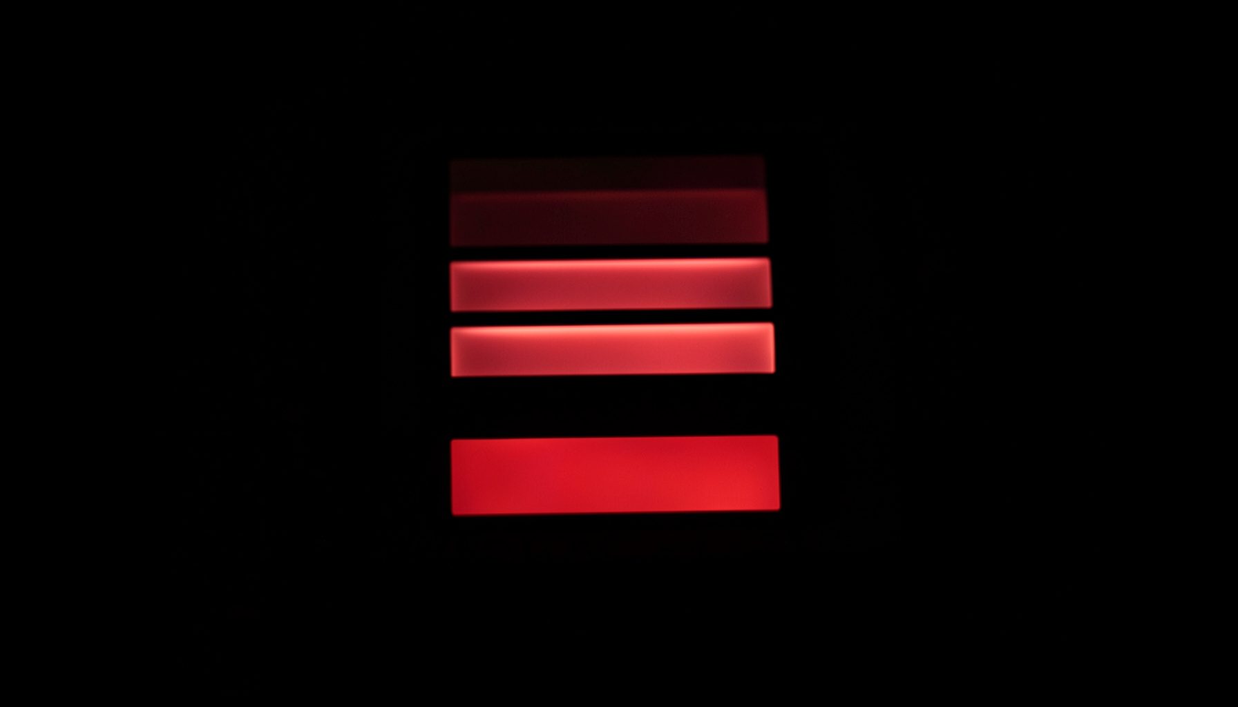 A glowing computer login panel rendered in soft red and black tones, fields and button softly lit against a dark backdrop