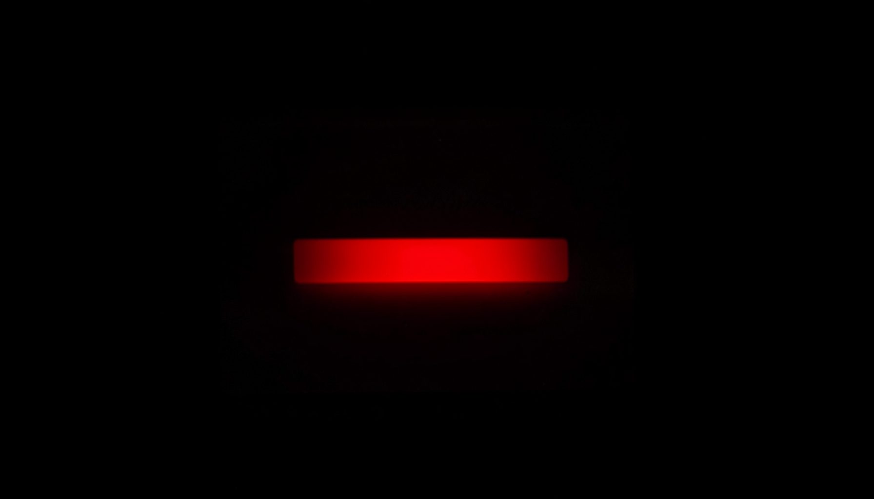Close-up of a glowing login panel with a red button on a dark interface background